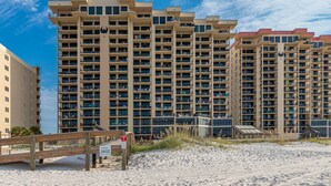 Un hôtel de grande hauteur doté de nombreux balcons, offrant une vue sur la plage et arborant une enseigne indiquant « Phoenix 1 ».