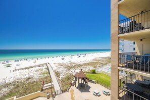 A beach view from a balcony with a gazebo, pool, and outdoor seating. - Everything is Better at the Beach! ~ Popular One Bedroom @ Phoenix 1 (Orange Beach)
