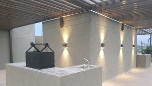 An outdoor kitchen area with a built-in sink and a barbecue grill. - Apartamento Ciudalela NIO (Neiva)