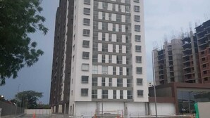 A tall, modern building with a grid of windows, surrounded by construction cones and gravel. - Apartamento Ciudalela NIO (Neiva)