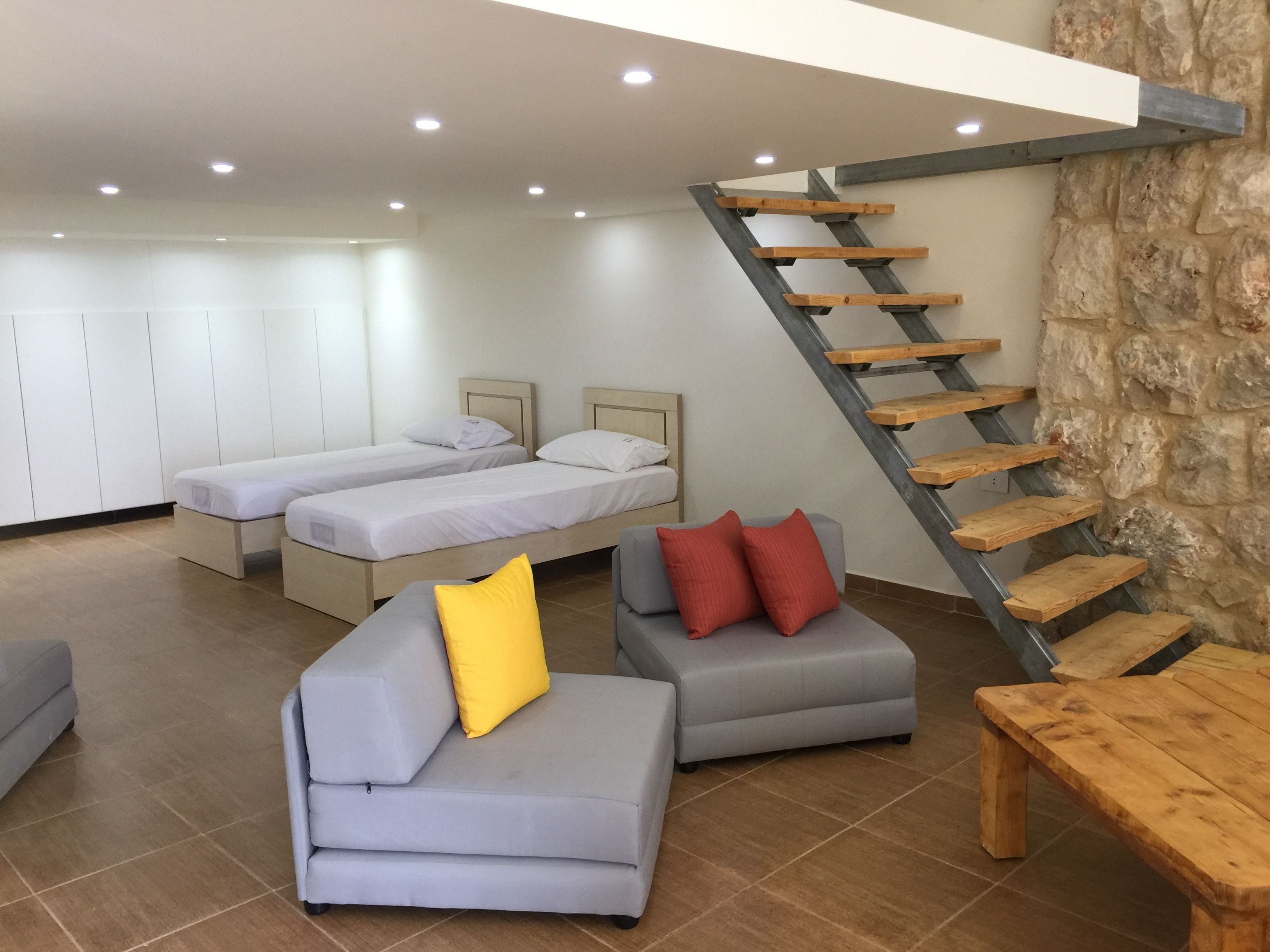 Un intérieur moderne avec une chambre à coucher aménagée en mezzanine, un escalier et un coin salon.