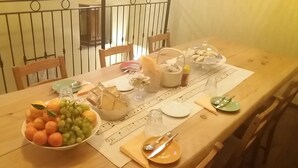 A dining table set with plates, glasses, a bowl of fruit, and various condiments. - Carlito's trattoria con alloggio (Cucciago)