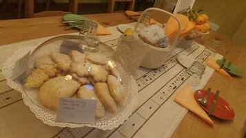 Ein Tisch mit einer transparenten Glasschale, gefüllt mit Keksen, auf denen 'Tortelli Ripieni Con Crema Al Limone' steht.