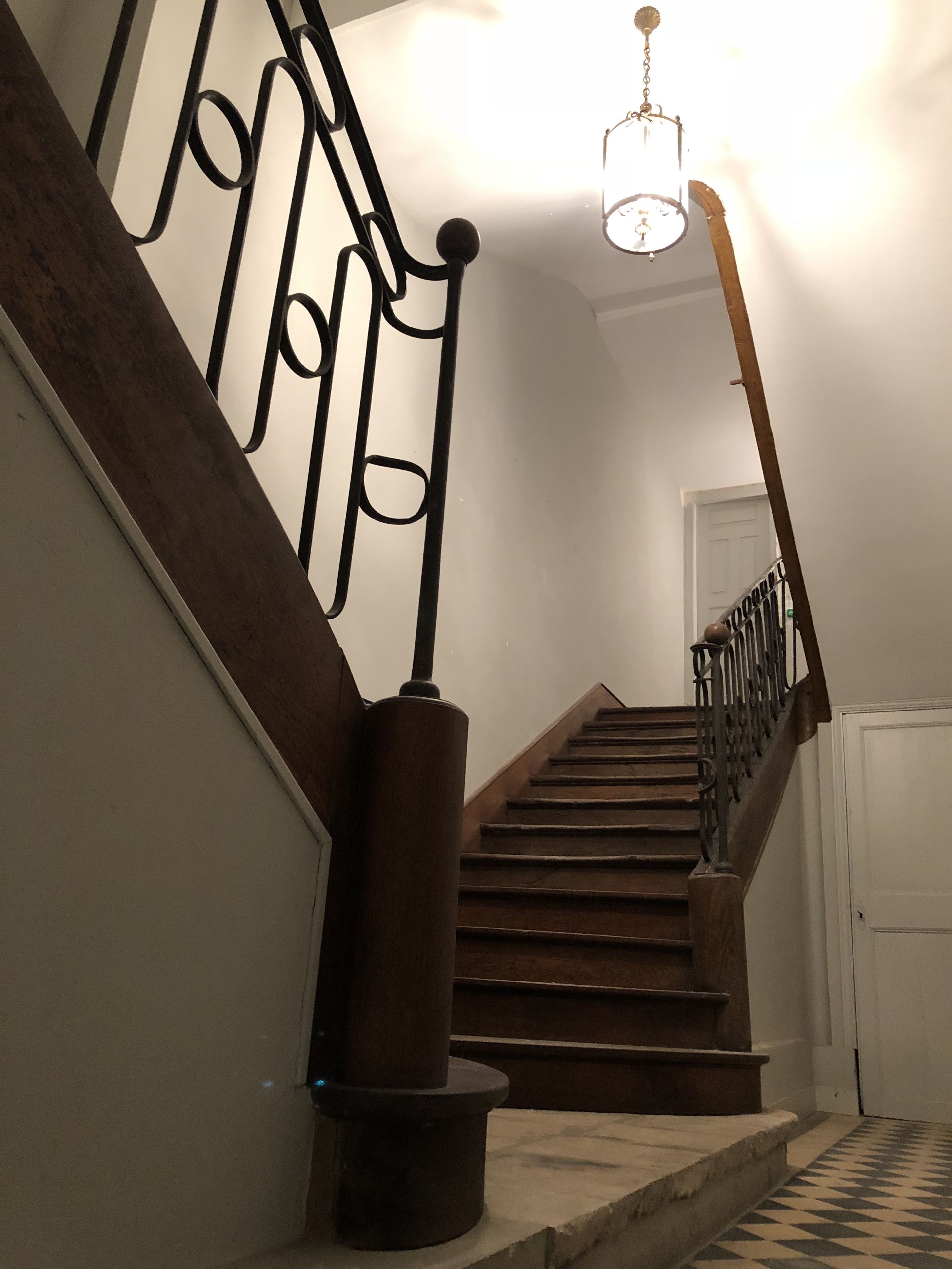 A staircase with wooden steps and metal railings, leading to a door at the top.