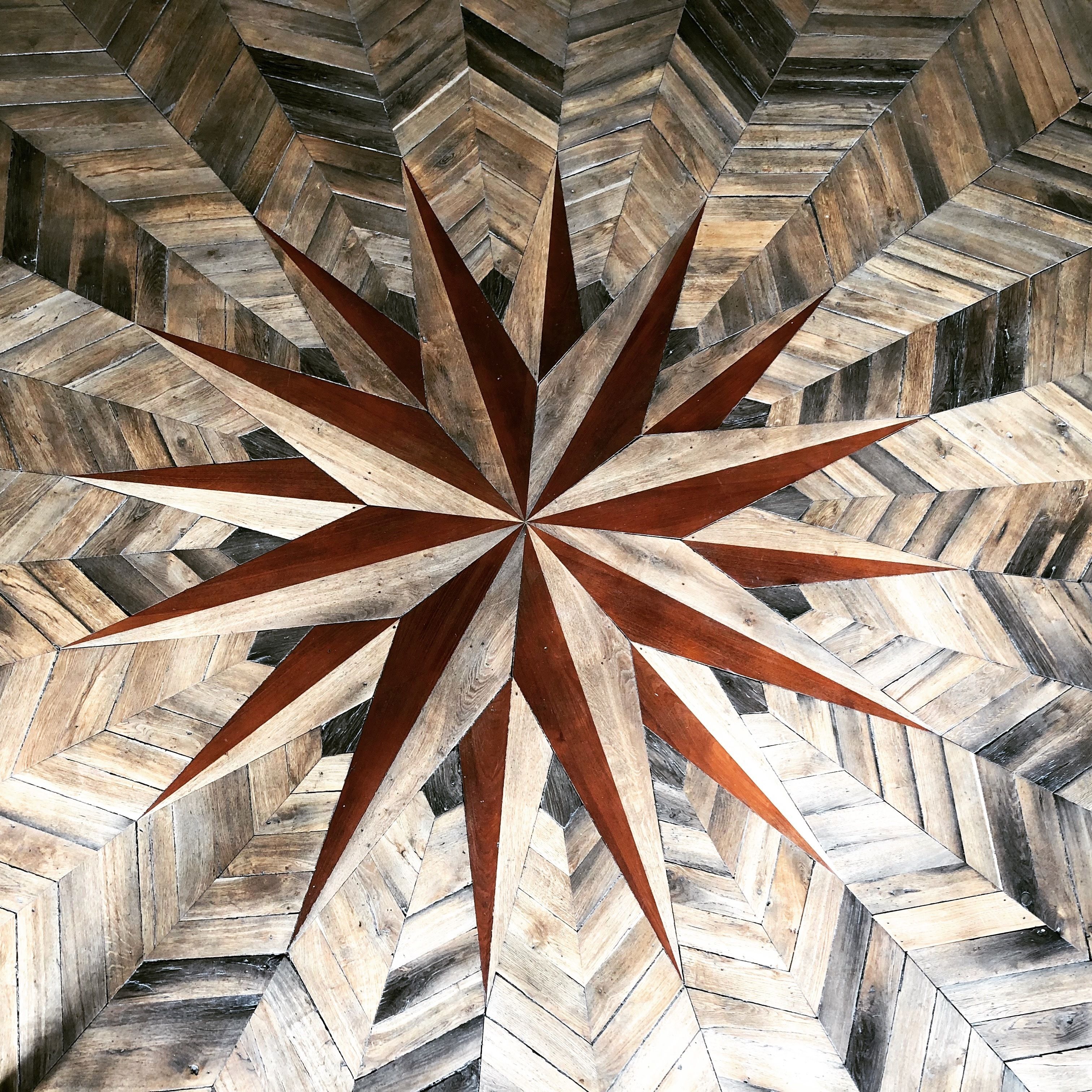 A geometric pattern with a central star design, likely part of a floor or wall.