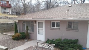 A single-story house with a front porch, a bench, and a small garden area. - Nostalgic One-level Bungalow in perfect location! (Colorado Springs)