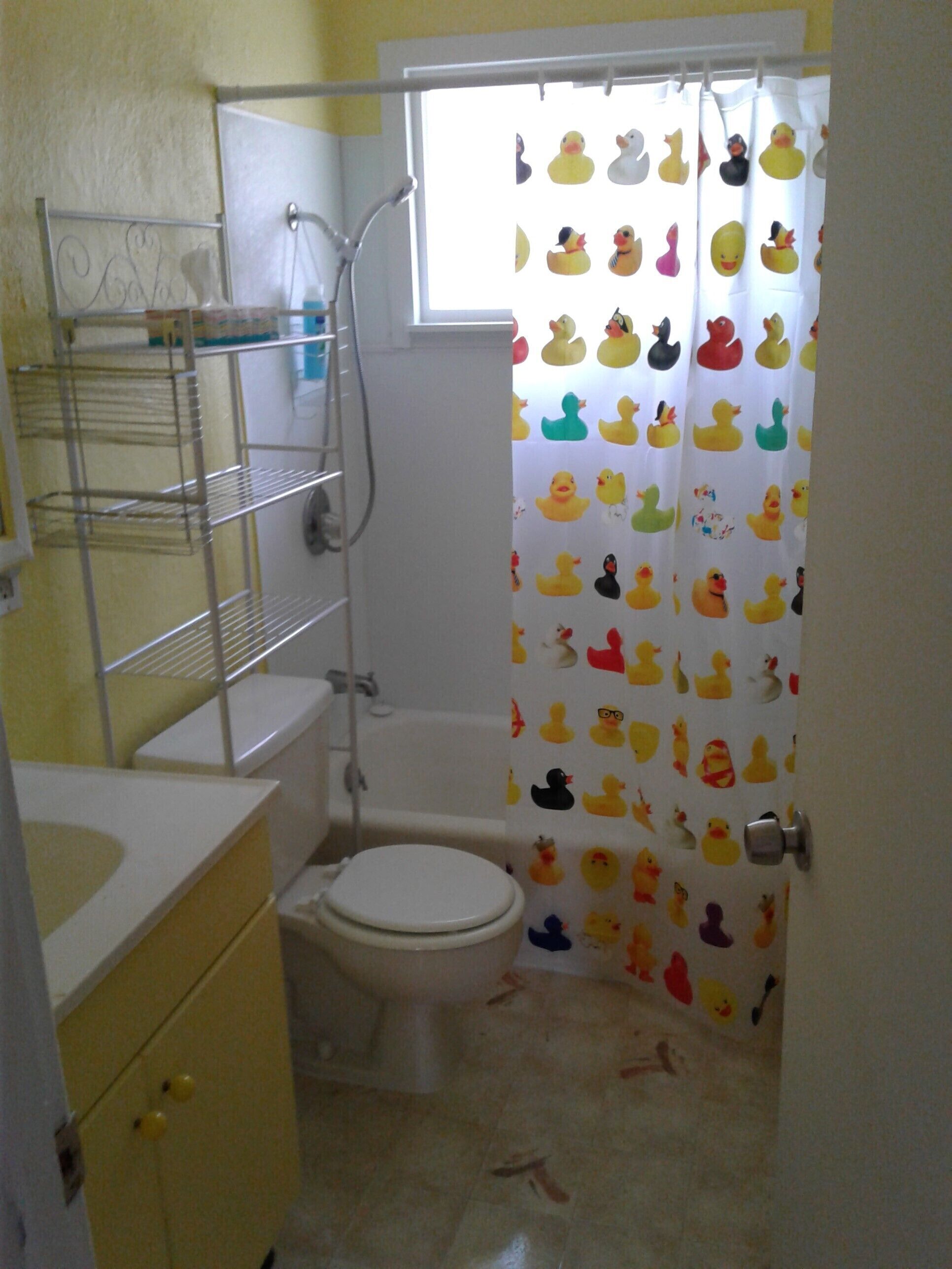 A small bathroom with a toilet, a shower, and a sink.
