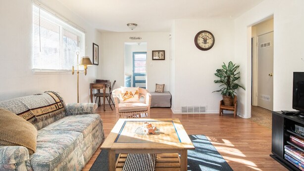A living room with a sofa, armchair, coffee table, and a television. - Nostalgic One-level Bungalow in perfect location! (Colorado Springs)