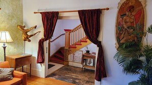 A staircase with red steps and a wooden railing, leading to an upper floor.