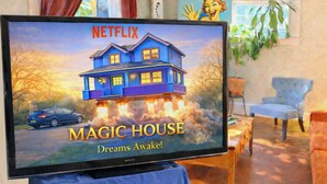 A television displaying the Netflix show 'Magic House' with a house flying out of the ground.