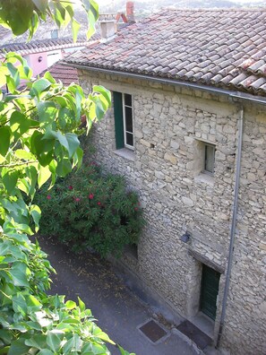A stone building with a tiled roof, a small window, and a door. - Medieval charm and soaring vistas in the heart of Provence: what's not to love? (Vaison-la-Romaine)