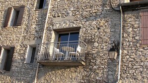 Un edificio de piedra con varias ventanas y un balcón.