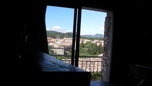 Una habitación con un ventanal grande que da a una ciudad con edificios y montañas a lo lejos.