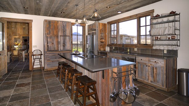 A spacious kitchen with a large island, wooden accents, and a view through the window. - Unique 40 AC Horse Friendly Ranch Renovated 1850 Miners Cabin w/3000 SF Addition (Gunnison)