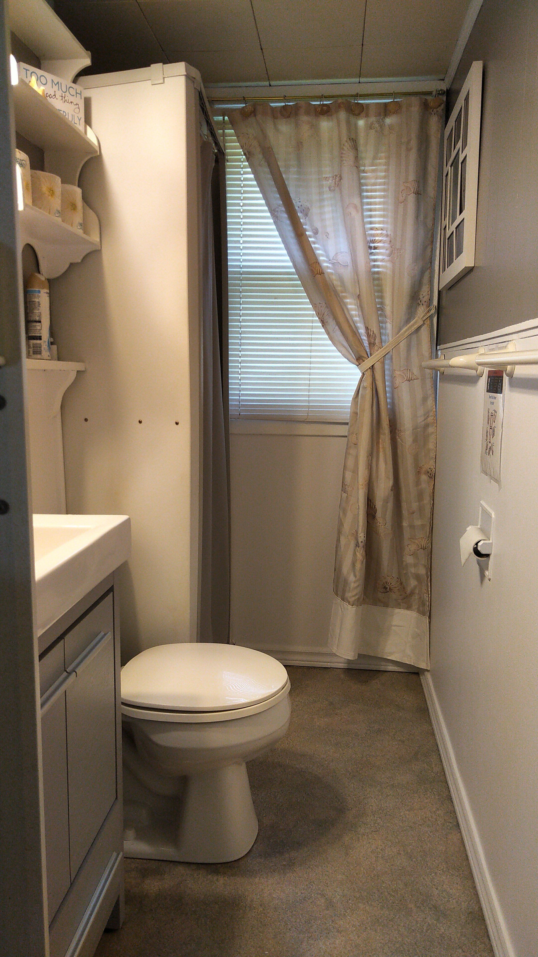 Une petite salle de bain compacte comprenant des toilettes, un lavabo et un espace douche.