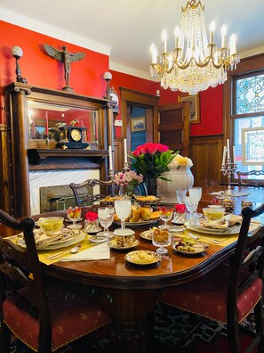 Formal dining room with a large dining table, ornate chairs, and a grand chandelier.