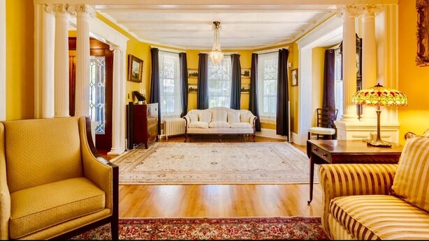 Un salón amplio con un gran tapete, un sofá y un sillón.