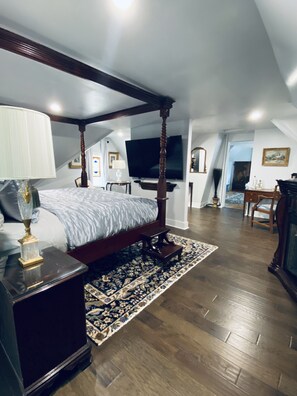 A bedroom with a four-poster bed, a television, and a chandelier. - 1000 Islands B&B – The Bulloch House (Gananoque)