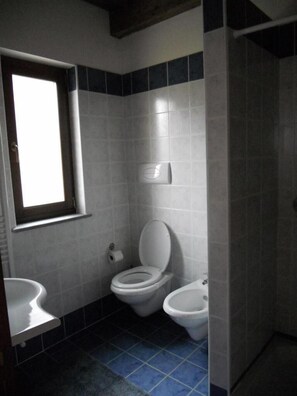 A bathroom with two toilets, a sink, and a window. - Agriturismo Fiore (Rotonda)