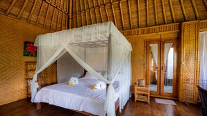 A room with a bed under a canopy, wooden floors, and a woven wall. - Villa Manuk (Sawan)