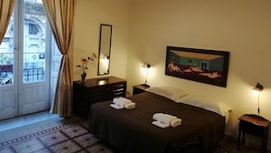 A hotel room with a bed, a dresser, a mirror, a painting, and a window with curtains. - B&B Aloi Rooms (Catania)