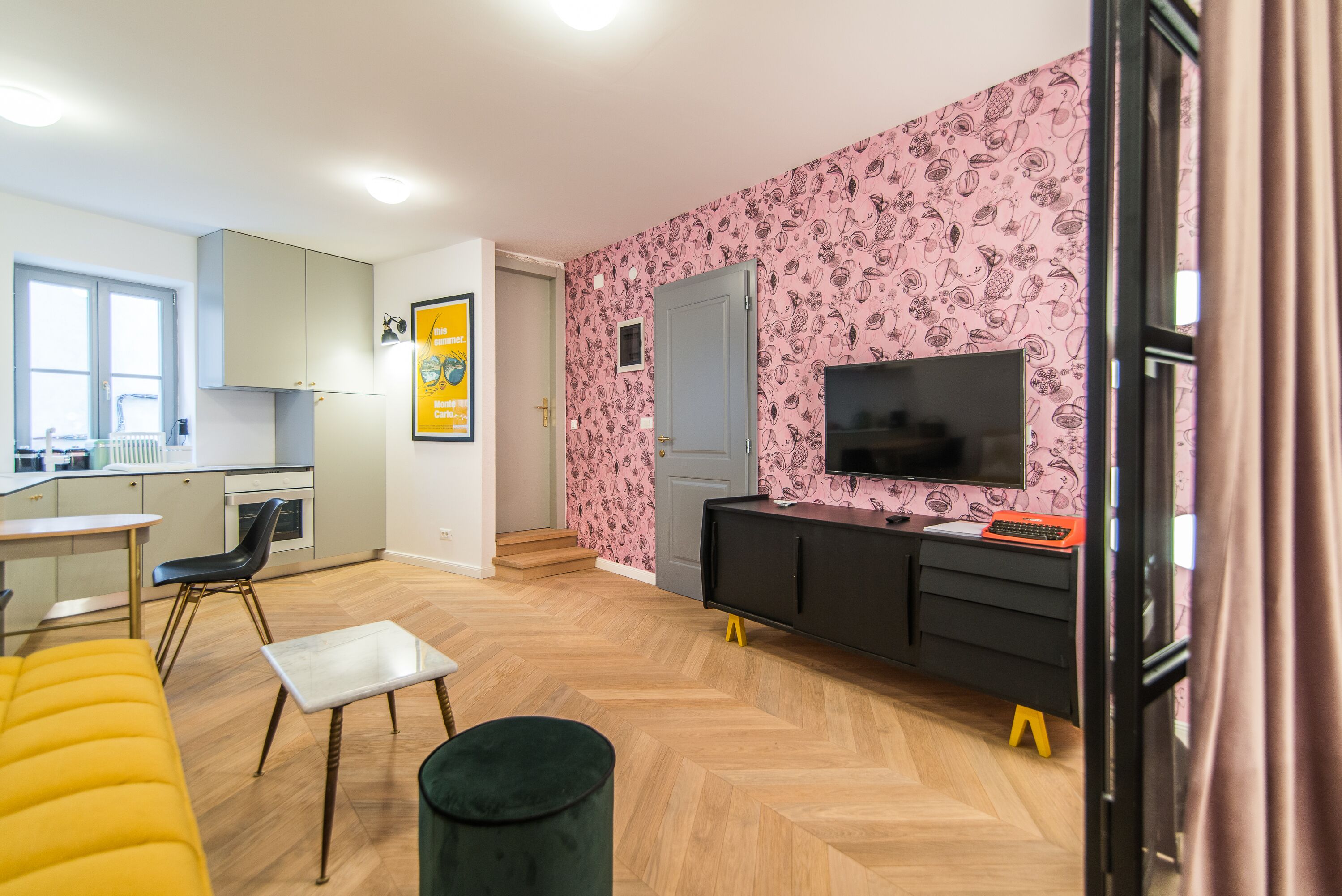 Un espacio habitable moderno con cocina, zona de comedor y área de estar con sofá y mesa.