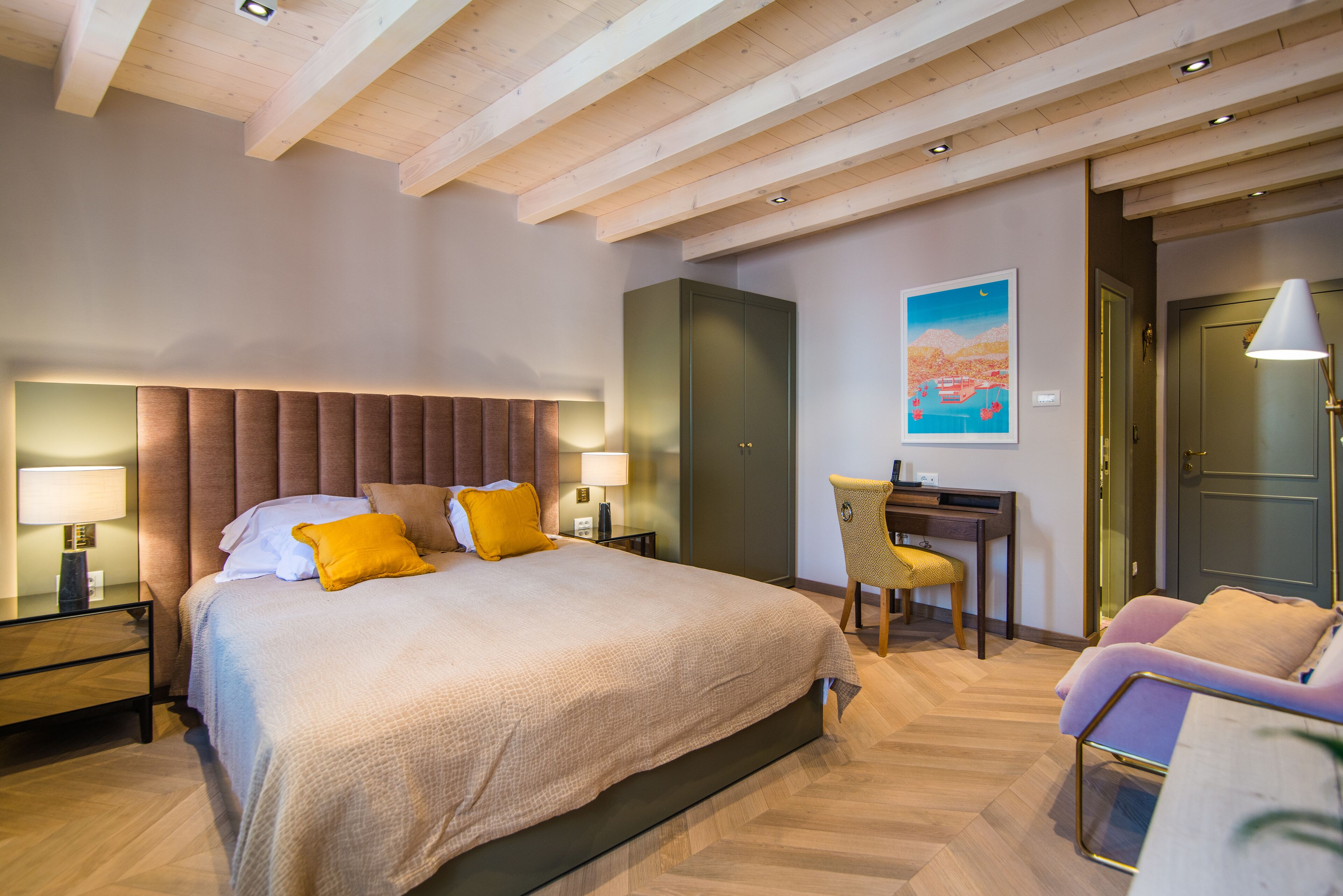 Quarto de hotel moderno com uma cama grande, uma escrivaninha e uma cadeira.
