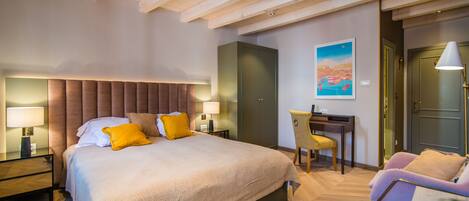 Quarto de hotel moderno com uma cama grande, uma escrivaninha e uma cadeira.