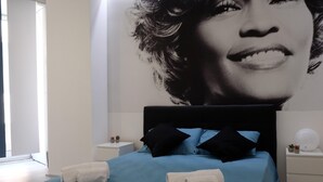 Un dormitorio con cama, almohadas y mesita de noche.