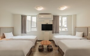 A hotel room with two beds, a TV, and an air conditioning unit. - Meant to Be (Chiayi City)