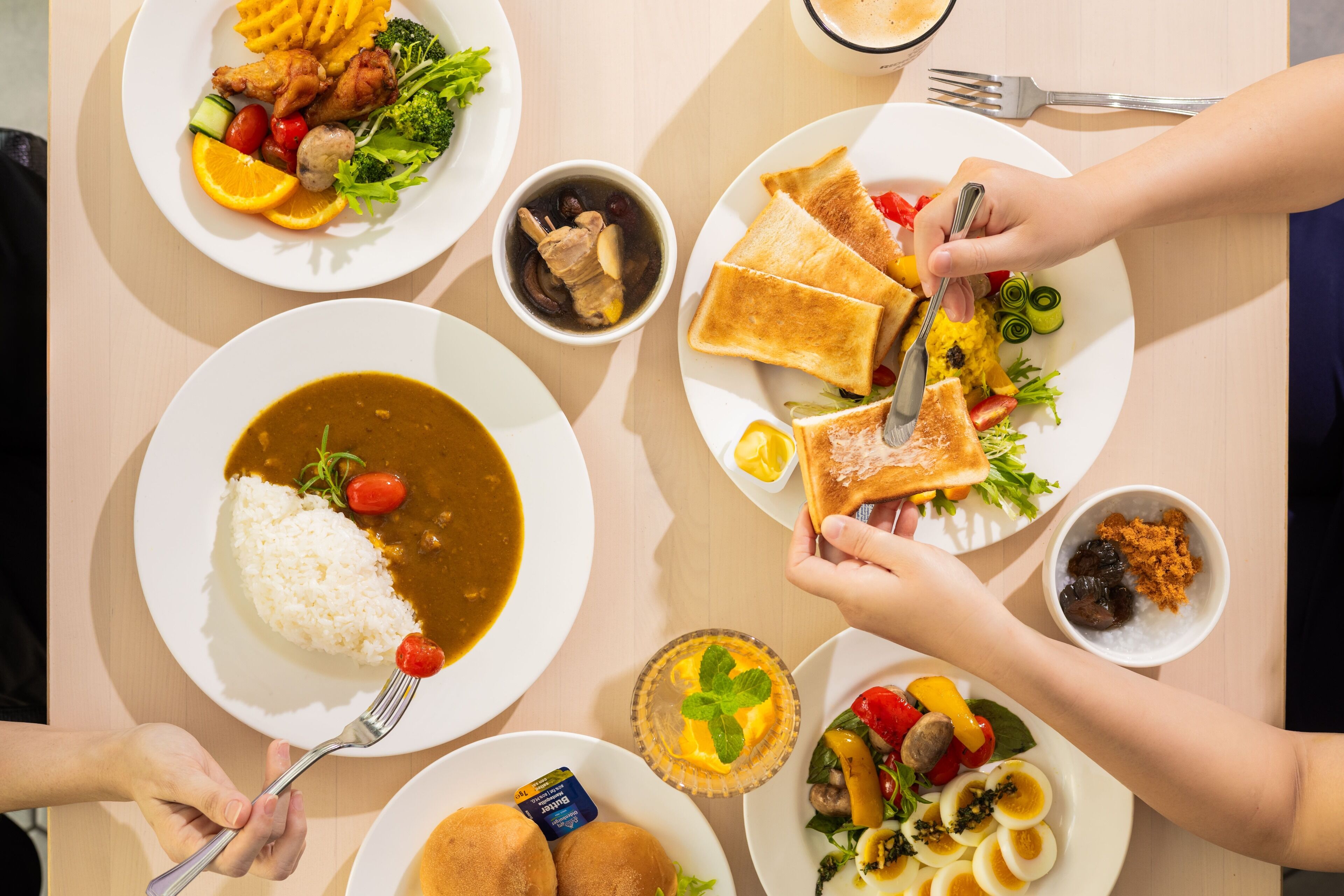 A table with various dishes including rice, soup, and sandwiches.