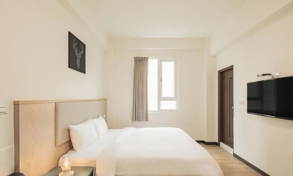 A hotel room with a bed, a TV, a window with curtains, and a door. - Meant to Be (Chiayi City)