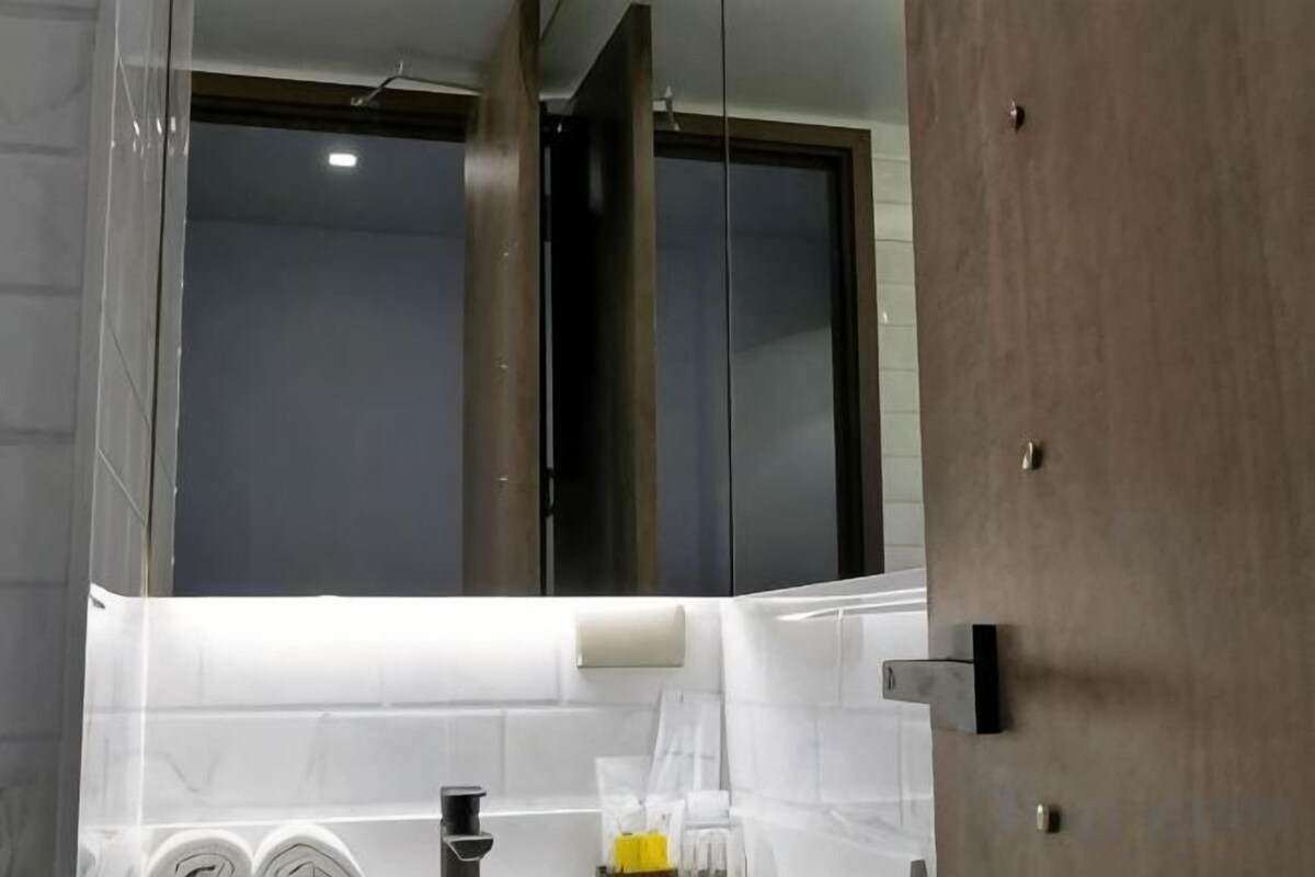 A bathroom with a mirror, a towel rack, and a shower area.