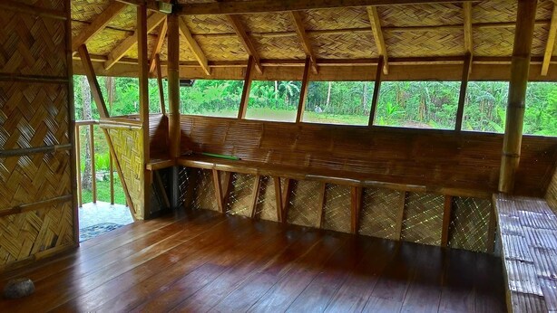 A wooden structure with a bench and a thatched roof. - Emperor's Organic Farm (Silang)