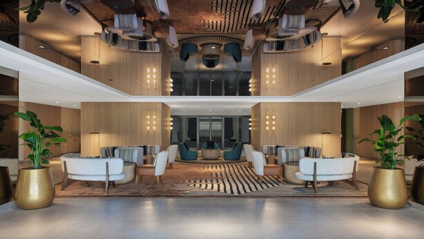 A spacious lobby with modern seating, a patterned ceiling, and large potted plants. - Delta Hotels by Marriott, Dubai Investment Park (Dubai)