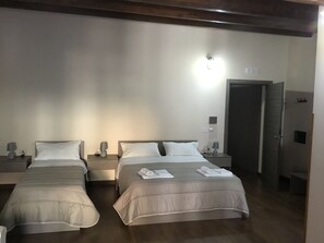 Une chambre d’hôtel avec deux lits, chacun étant équipé d’un oreiller et d’une lampe sur une table de chevet.