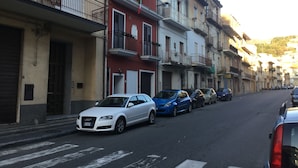 Een rij geparkeerde auto's langs een straat met meerlaags gebouwen.