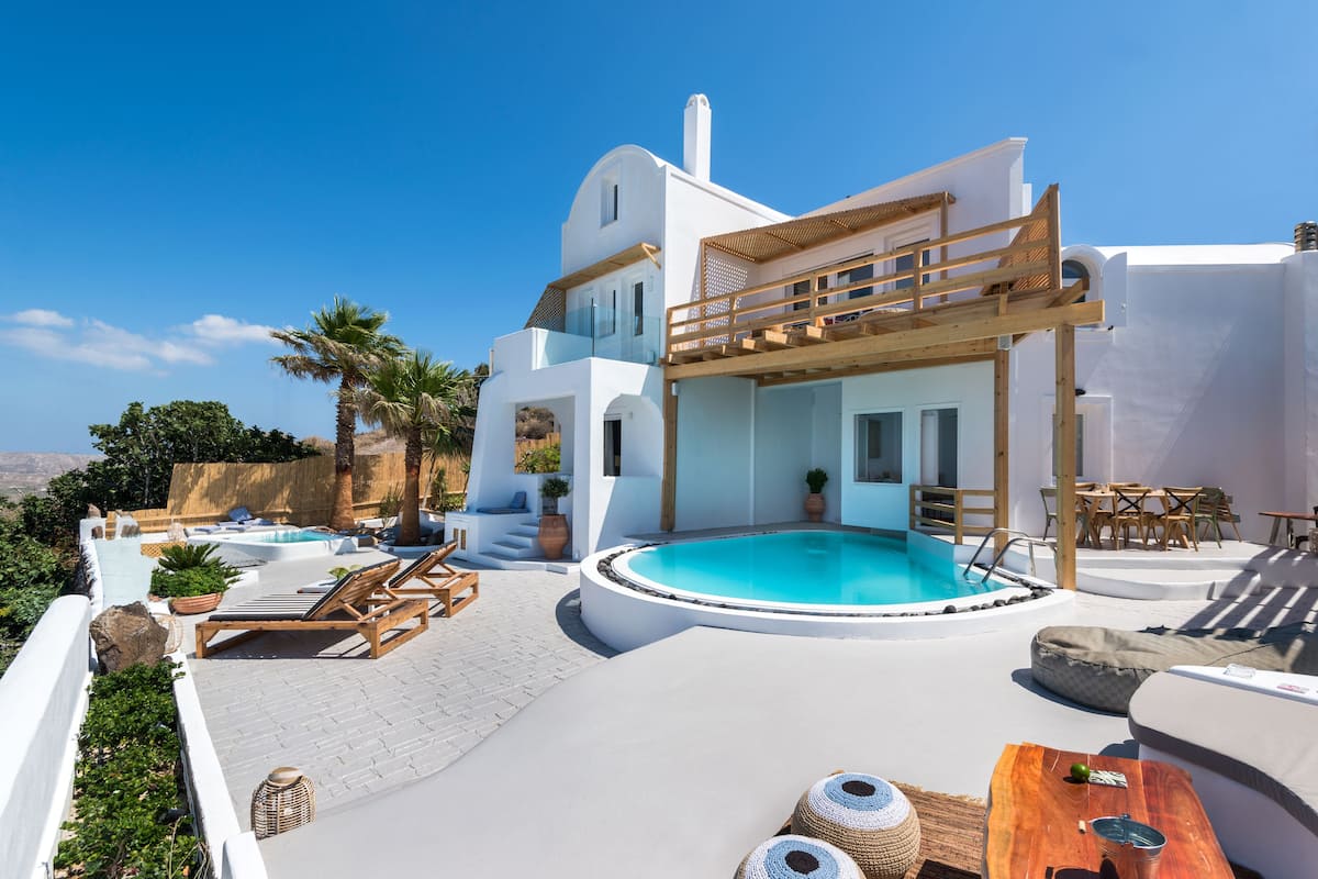 A modern villa with a rooftop pool, outdoor seating, and a scenic view.