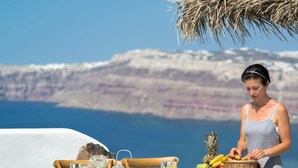 A table set with breakfast items and a view of a coastal landscape. - Summer Lovers Villa (Santorini)