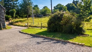 A gravel driveway leading to a building with a stone wall on the left. - Homerez - House in Sourdeval (Sourdeval)