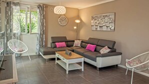 Ein modernes Wohnzimmer mit einem Ecksofa, einem Couchtisch und einem Essbereich mit Tisch und Stühlen.
