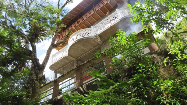 A traditional wooden building with ornate white railings and a balcony. - Vista Hermosa (San Rafael)