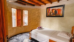 A room with a wooden ceiling, a bed with a white bedspread, patterned black and white floor tiles, and a painting on the wall. - Vista Hermosa (San Rafael)