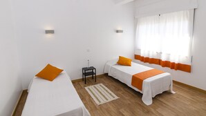 A hotel room with two single beds, a small table, and a window with curtains. - Faro Albacor Residence - Hostel (Faro)