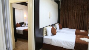 Une chambre d’hôtel avec deux lits, un grand miroir et un rideau.