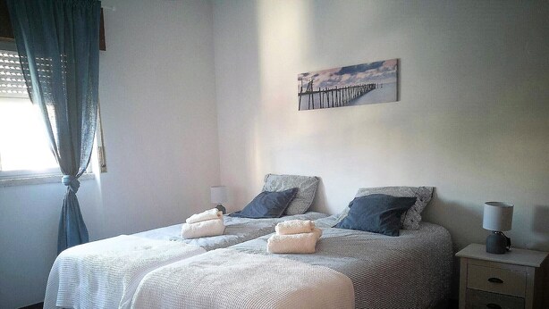 Ein Schlafzimmer mit einem Bett, zwei Nachttischen, einer Lampe und einem Bild an der Wand.