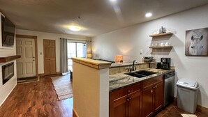 A modern kitchen with wooden cabinets, a granite countertop, and a built-in dishwasher. - Ski-in/Ski-out, 1 bedroom at the heart of the Resort Base Area! (Mt. Crested Butte)