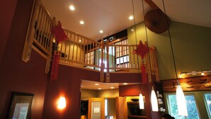 A multi-level interior with a wooden staircase, a dining area, and a kitchen visible in the background. - Large group(walking distance to Alyeska Resort) (girdwood)