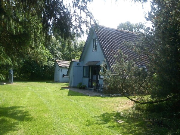 Une maison avec un toit en pente et un petit porche.