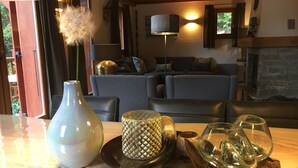 A cozy living room with a sofa set, a vase with a dandelion, and a table with decorative items. - Luxury detached 12-person chalet, few steps from the slopes in heart Alpe d'Huez (Oz)